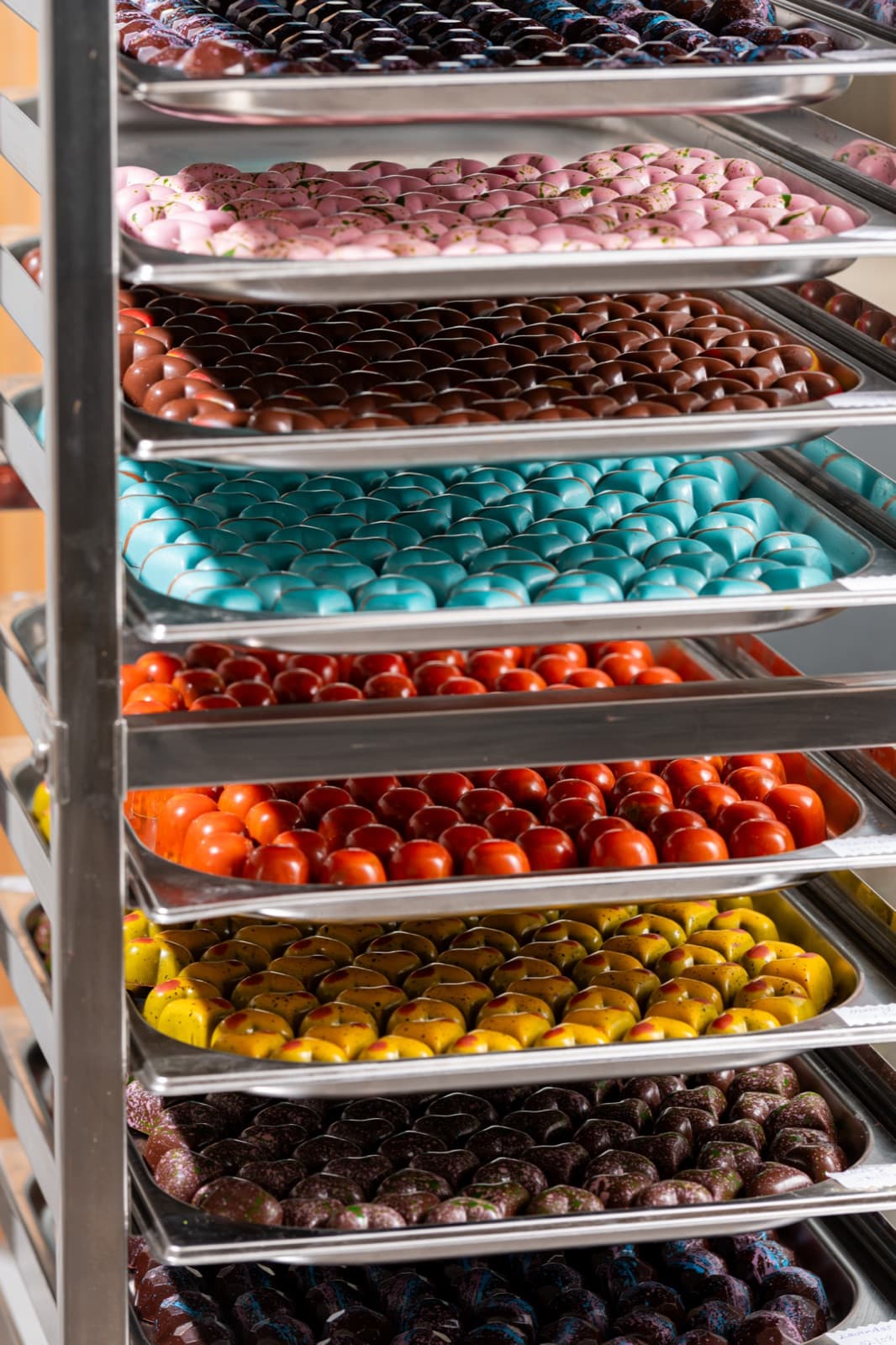 Racks of colourful handmade chocolates in the factory