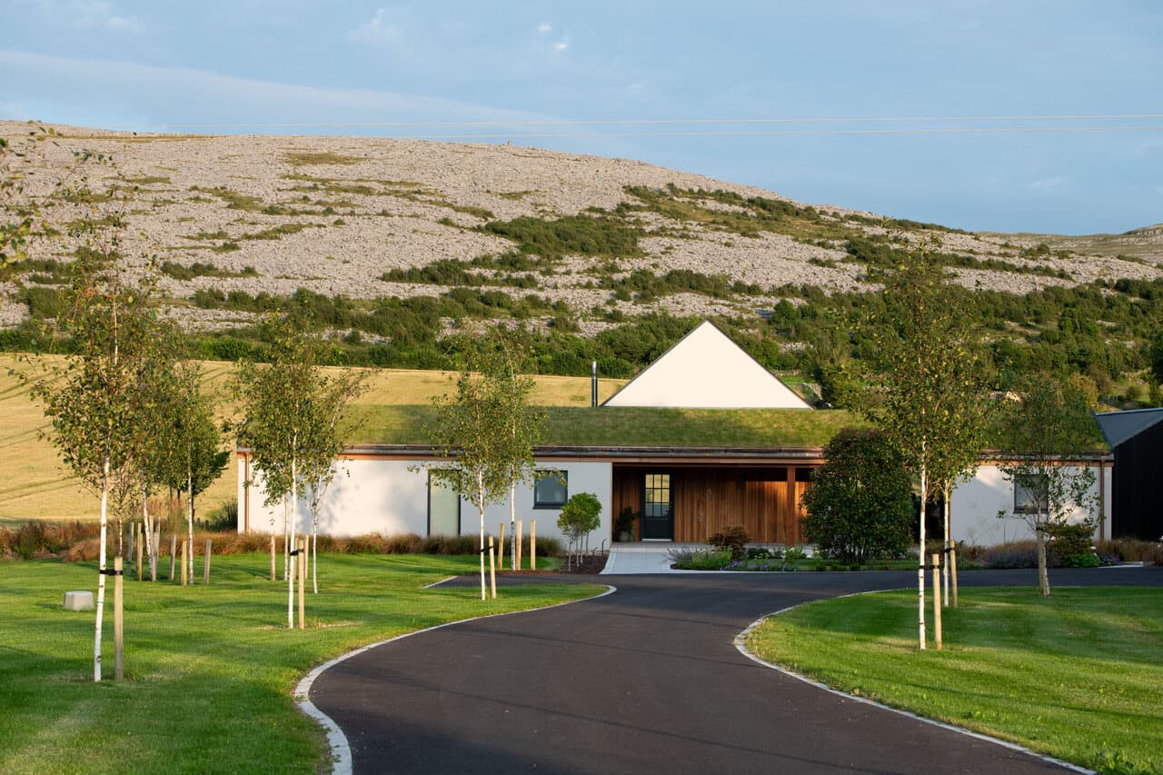 The Chocolate Lodge, a white house with a living grass roof, below the limestone hills of the Burren beside Hazel Mountain Chocolate