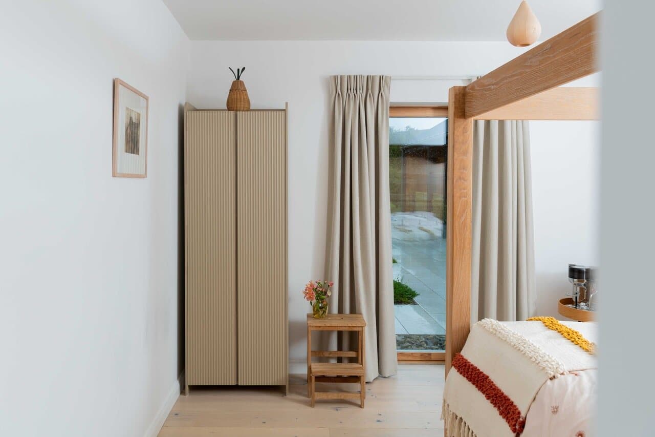 The guest bedroom at The Chocolate Lodge, with an oak four-poster bed and a garden door