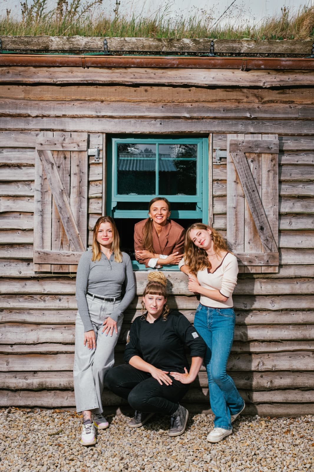 The team at the wooden grass-roofed cabin beside the chocolate factory